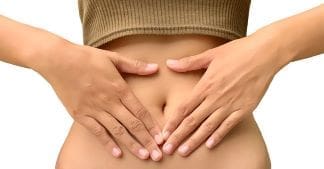 prebiotics supplements- woman holding her stomach with IBS