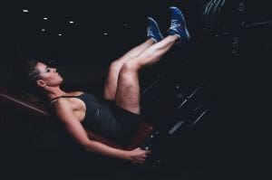BCAAs Woman with toned legs on a leg press machine